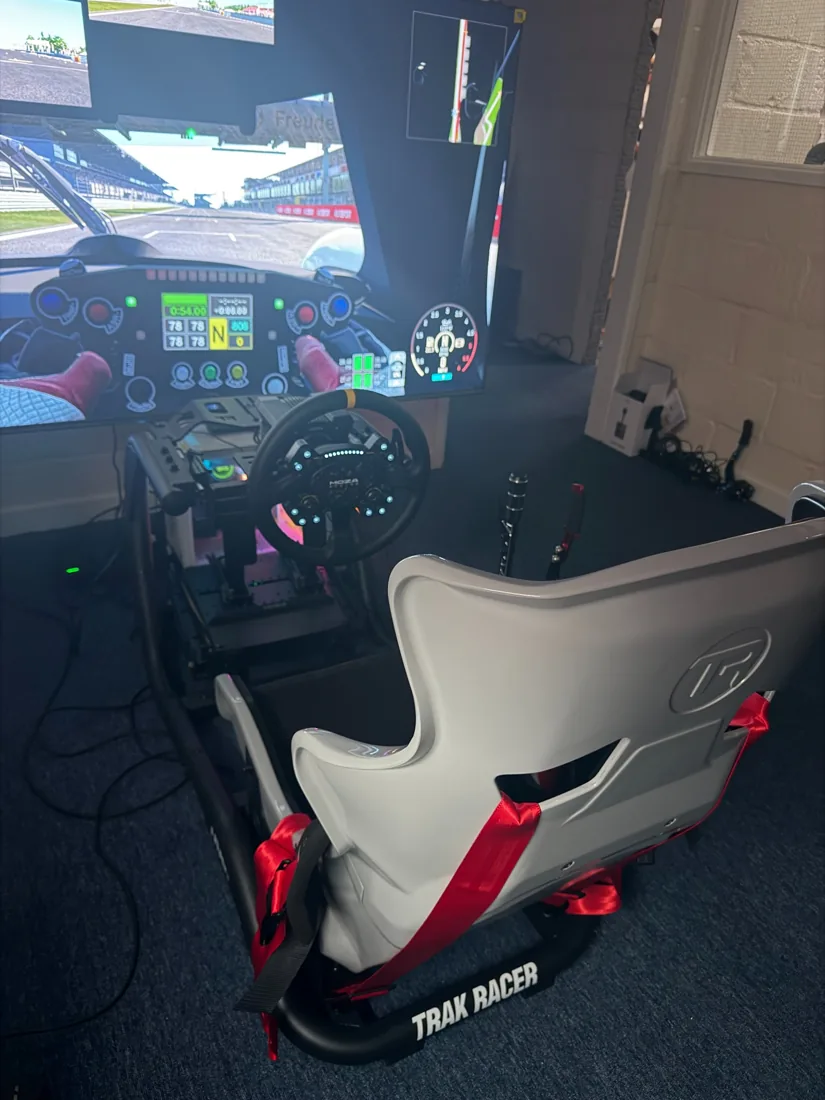 Motor racing simulator with racing seat, steering wheel and large display